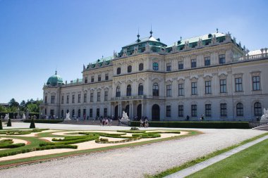 3 Haziran 2019 - Viyana, Avusturya - Yukarı Belvedere Sarayı simetrik barok cepheli ve mavi gökyüzü altındaki ziyaretçilerle dolu bahçeli.