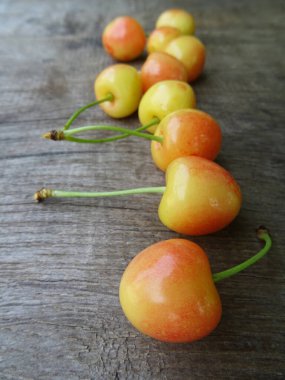 Ahşap arka planda olgun kiraz meyveleri, yakın planda hafif çilekler. Lezzetli kiraz meyveleri