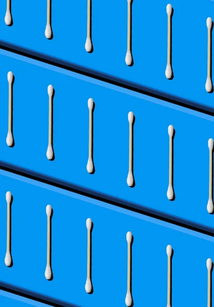 Pattern formed by cotton swabs on an electric blue background. Zero plastics concept.