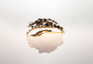 Small pieces of cardboard delicately arranged on a white background with its reflection.