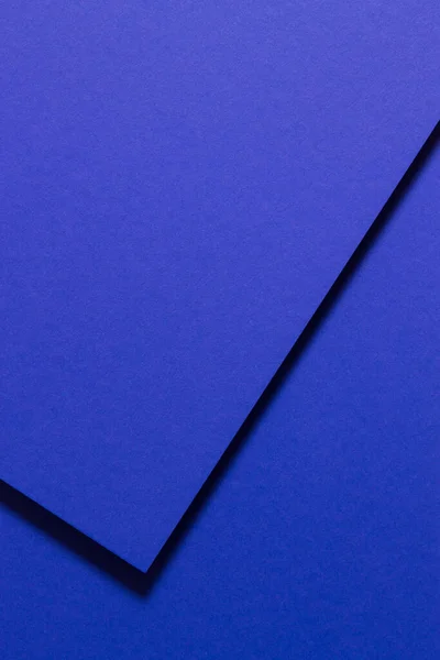 Koyu mavi karton ve gölgesi tarafından oluşturulan tek renkli geometrik bileşim.