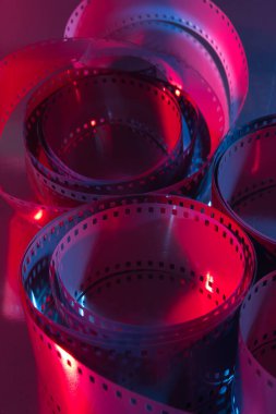 35 mm film curls illuminated with red and blue colored lights. Cinematography concept.