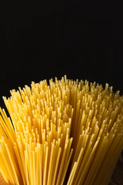 Zbliżenie Spaghetti Ułożone Pionowo Odbiór Ciemne Tło — Zdjęcie stockowe
