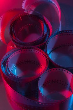 35 mm film curls illuminated with red and blue colored lights. Cinematography concept.