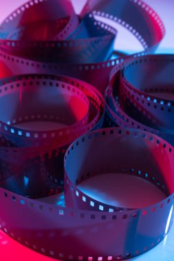 35 mm film curls illuminated with red and blue colored lights. Cinematography concept.