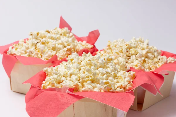 Tahta kaselerde kırmızı kağıt peçetelerde patlamış mısır sunuluyor. Boş zaman ve eğlence konsepti.