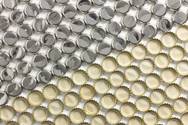 Geometric pattern formed by soda bottle caps. Some are upwards and others downwards.
