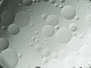 Yağ ve su damlacıklarından oluşan gri bir palet büyüleyici bir soyut desen oluşturuyor..