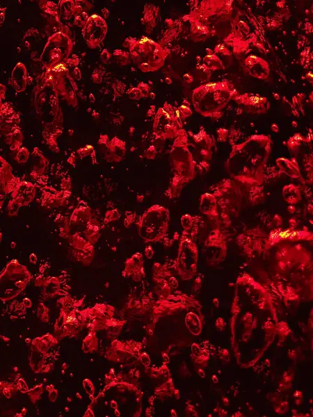 Parlak bir efektle vurgulanmış, detaylı baloncuk desenli ateşli kırmızı bir buz yüzeyi..