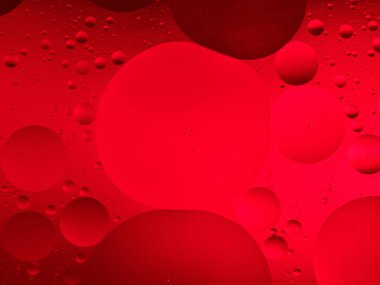 Suda kırmızı yağ damlacıklarının makro görüntüsü, canlı ve dokulu soyut bir arka plan için mükemmel..