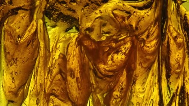アーティストのブラシは 黄色の光によるゼラチノス半透明な表面バックライトを上向きに結合し 黄色い色合いと閉じ込められた気泡 — ストック動画