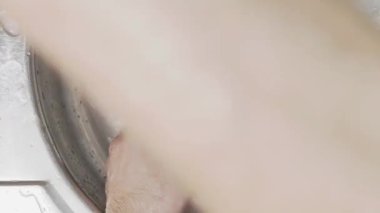 Yıkandıktan sonra sabunu temizlemek için mutfak aletlerini durulayan ellerin yukarıdan görünüşü temiz ve kullanıma hazır olduğundan emin olmak için..