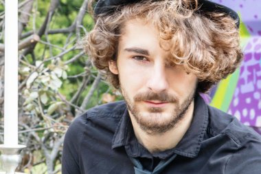 Çok şık giyinmiş genç bir adam klasik bir boho şık pikniğinde, kırsal kesimde güzel bir poque