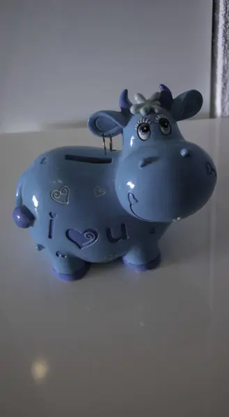 Piggy bank in the shape of a blue cow, cut out object