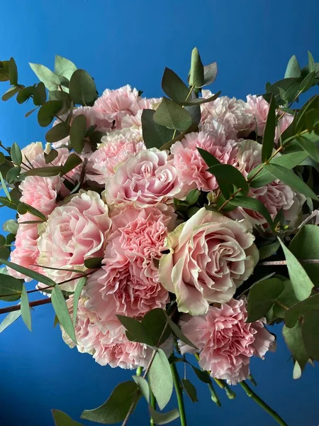 美丽的粉红色玫瑰花束和蓬松的康乃馨与绿色桉树 免版税图库图片