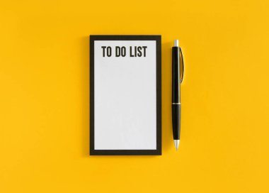 Liste cümlesi için beyaz sayfa ve sarı arka planda siyah kalem. Stok fotoğrafı