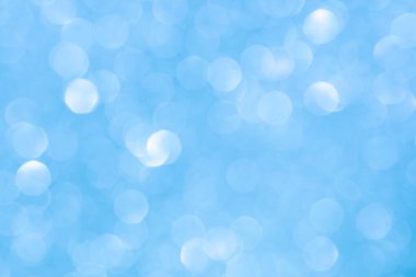 Bulanık mavi bokeh hafif doku, yumuşak dairesel çözülmüş etki. Tasarım, kış, tatil veya rüya gibi atmosfer kavramları için soyut şenlik arkaplanı.