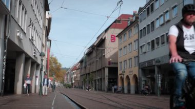 Şehir merkezindeki Freiburg. Tramvay ve yürüyen turistlerle dolu bir cadde, 30,10.22. Freiburg, Almanya. Freiburg im Breisgau 'nun tarihi merkezi. Popüler seyahat yerleri