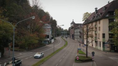 Sonbahar şehir manzarası, araba trafiği ve bisikletçiler, 30,10.22. Freiburg, Almanya. Şehirdeki virajlı yolda giden arabalar. Freiburg im Breisgau 'da işlek caddeler