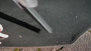 Elektrikli süpürgeyle siyah araba halısını temizliyorum. Dışarıda araba paspası yıkıyorum. Otomobil temizliğinde self servis