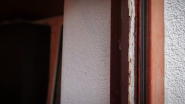 Eski pencerenin sökülmesi. İnşaatçı ahşap pencere çerçevesini söküyor, kapatın. İnşaat endüstrisi. İşçi dairedeki eski pencereyi kaldırıyor. Eski pencereleri değiştiren inşaat işçisi