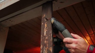 İnşaatçı testereyle ahşap pencere çerçevesi kesiyor ve elektrikli süpürgeyle toz topluyor. İnşaat işçisi elektrikli testereyle eski ahşap pencere çerçevesini söküyor. İnşaat endüstrisi