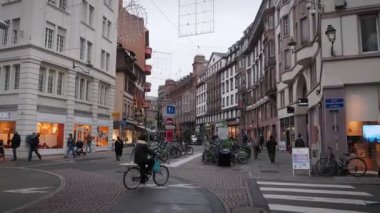 Strasbourg şehrinin işlek caddelerinde yürüyen insanlar. Yıllık Noel tatili boyunca insanlarla dolu eski sokaklar. Bisiklet parkı ve tarihi eski şehrin yakınlarında yürüyen turistler. Strasbourg, Fransa 15.11.22