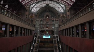 Antwerp Merkez Tren İstasyonu 'nun içi. Tren istasyonunun ve yürüyen insanların güzel mimarisi ile iç tasarım. Antwerp 'te altın istasyon saati olan tarihi tren istasyonu.