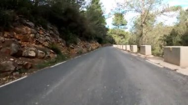 Bisikletle dağ yolundan hızla inen profesyonel bisikletçinin POV görüntüsü. Bisikletle dağ geçidinden bisikletle geçen bir motosikletli. Dağ yolunda bisiklet sürüyor. Aktif spor