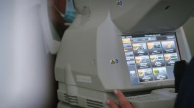 Modern teknoloji makineleri olan oftalmolog kabinesi. Oftalmolog yaşlı adama görme testi yapıyor. Göz taraması yapan göz doktorundaki hasta görme yeteneğini inceliyor. Eczane kavramı