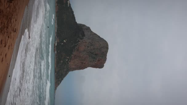 冲浪手在冲浪板上对着著名的Calpe Rock Costa Blanca漂浮 美丽的海滨 有海浪 沙滩和佩农德法 风景如画的海景 — 图库视频影像
