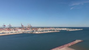 Valencia, İspanya 'da demirli beyaz lüks yatlar. Kargo taşıma konsepti. Limandaki büyük renkli konteynırlar ve kargo gemileri. Valencia Limanı 'nın hava aracı görüntüsü.