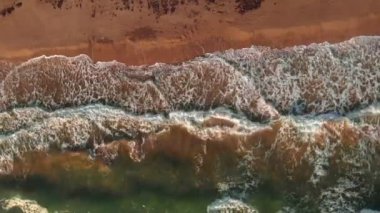 Turkuaz deniz dalgaları kumlu sahile ulaşıyor ve beyaz köpük oluşturuyor. Dev dalgalar Golden Beach 'i vuruyor, Calpe, Costa Blanca, İspanya. Büyük deniz dalgaları sahilin kumlarına çarpıyor. Görkemli deniz manzarası