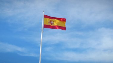 Rüzgarda dalgalanan İspanyol bayrağına yaklaş. İspanya 'nın ulusal bayrağı açık mavi gökyüzüne bayrak direğinde dalgalanıyor