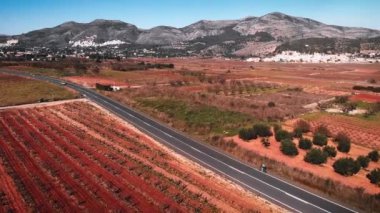 Cyclists riding on asphalt car road in Calpe, Costa Blanca, Spain. Professional road cyclists training outdoors in mountains, preparing for summer race cycling season. Sport cycling concept