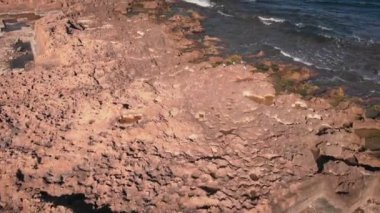 Rocky mountain seashore with sea waves reaching rocky beach against clear blue sky. Beautiful seascape at sunny day. Coastline of Javea, Costa Blanca, Spain