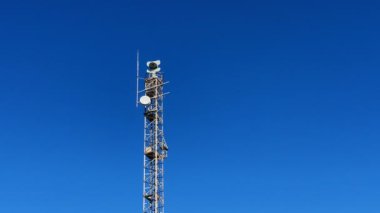 Coastal radar station against blue sky background. Satellite radar tower on blue sky. Marine radio beacon. Radar tower on seashore