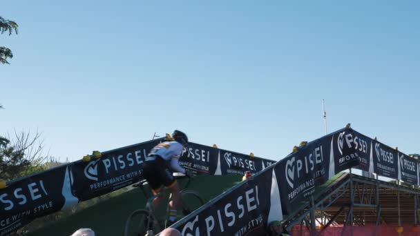シクロクロスレースで上り坂の障壁を介してサイクリストに乗る ベニドーム スペイン ワールドカップシクロクロス選手権サイクリング競技 自転車レースに参加するプロのサイクリスト — ストック動画