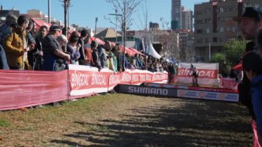 Cyclists jumping over barriers at cyclocross race, Benidorm, Spain, 22.01.23. Professional cyclocross bike riders participating in World Cup Cyclocross Championship, jumping with bikes over barriers