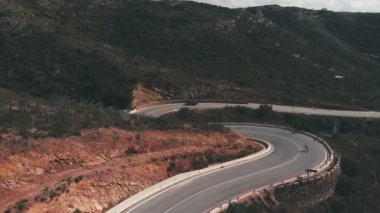 Speedy downhill from mountain on bicycle. Pro road cyclist riding fast on bicycle from mountain pass on asphalt car road. Sport training. Cycling and triathlon concept. Cycling in mountains in Spain