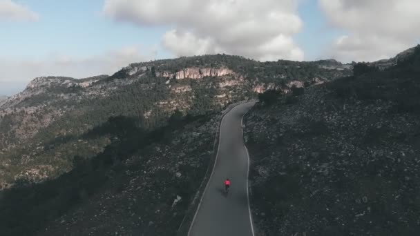 자전거를 언덕을 오르는 보호용 색옷을 자전거 산에서 자전거를 열심히 페달을 — 비디오