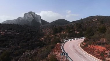 Yoğun bisiklet eğitimi sırasında zorlanan bisikletçi. Profesyonel yol sporcusu kayalık dağlara karşı yokuş yukarı bisiklet sürüyor. Bisiklet ve triatlon. Fitness aktivitesi. Kardiyo egzersizleri.