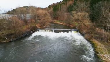 Baharda hızlı dağ nehri. Kayalık kayalar üzerinde berrak su ile akan güçlü bir dağ nehri hızla kırılır. Dağ doğa manzarası. Güzel dağ ve orman doğası