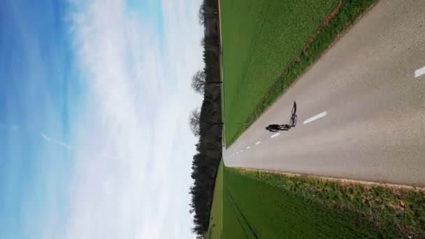 サイクリングとトライアスロンのコンセプト 晴れた日に緑の丘を通って自転車に乗るプロのロードサイクリスト 自転車アウトドアでのサイクリストアスリートトレーニング 春の自転車でのトライアスロン — ストック動画