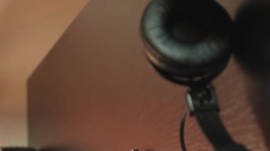 Gitar çalan bir adam. Dikey video. Kapatın. Akustik gitar çalan bir müzisyen. Gitarist stüdyoda gitar çalma pratiği yapıyor. Gitarda şarkı söyleyen müzisyen parmakları. Müzik konsepti