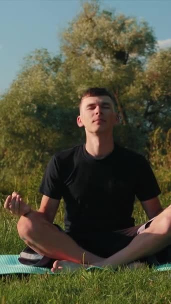 Man Utövar Yoga Utomhus Vertikal Video Fokuserad Manlig Meditation Naturen — Stockvideo