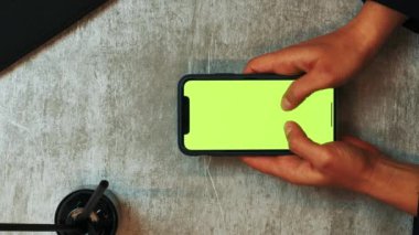 Yeşil renkli ekran krom anahtar sörf interneti olan telefonu kullanan bir kadın. Dikey video. Eller akıllı telefon ekranına dokunuyor, mesajlar yazıyor, sosyal medyada iletişim kuruyor ya da alışveriş yapıyor.