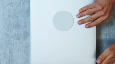 Dizüstü bilgisayar açılıyor, üst görüntü. Dikey video. Ofis masasında oturan bir kadın, dizüstü bilgisayarı açıyor ve klavyede yazmaya başlıyor. İş için. İnternette online çalışma