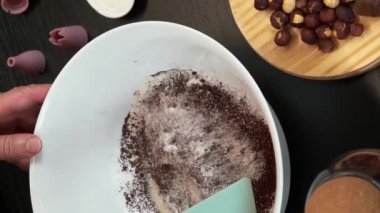Kasede malzemeleri karıştırmak, çikolatalı bisküvi keki hazırlamak. Dikey video. Kadın pastacı modern mutfakta ev yapımı tatlı kurabiyeler pişiriyor. Evde bir kadın turta pişiriyor. Evde yemek pişirmek.
