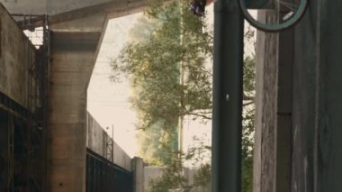 Günbatımında geçmişe dönük bisiklet süren bir kadın. Dikey video. Romantik elbiseler ve hasır şapkalar giyen çekici genç bir bayan şehirde eski bir bisiklete biniyor. Spor eğlencesi.